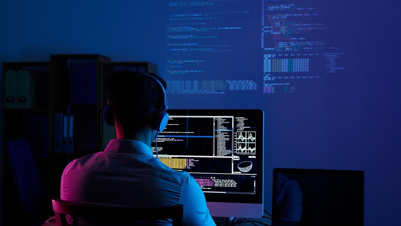Green and white lines of code scrolling across a dark terminal monitor screen.