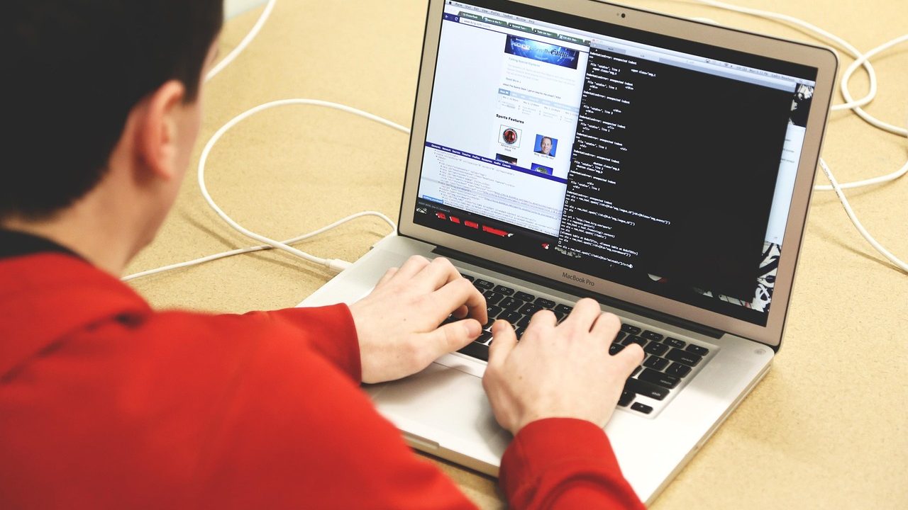 A developer's workstation with multiple monitors displaying code editors and terminal windows.