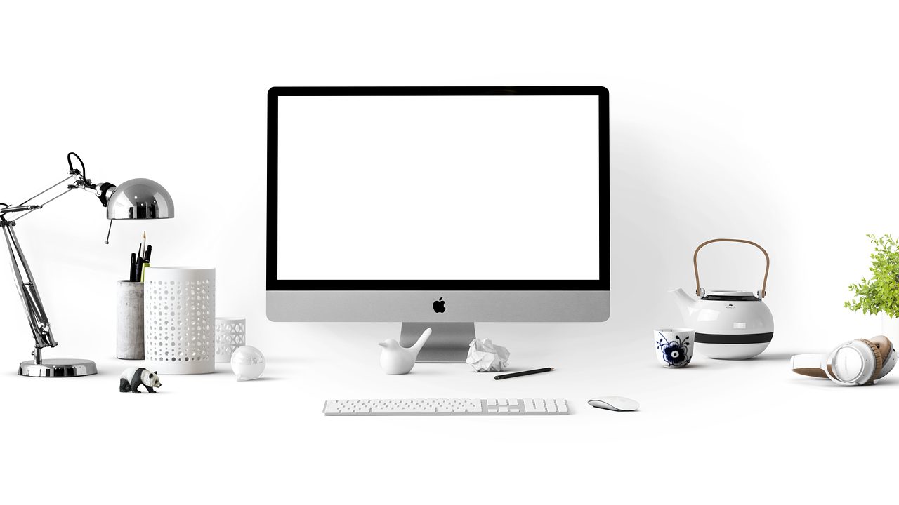 Multiple monitors displaying news and data feeds on a modern desk.