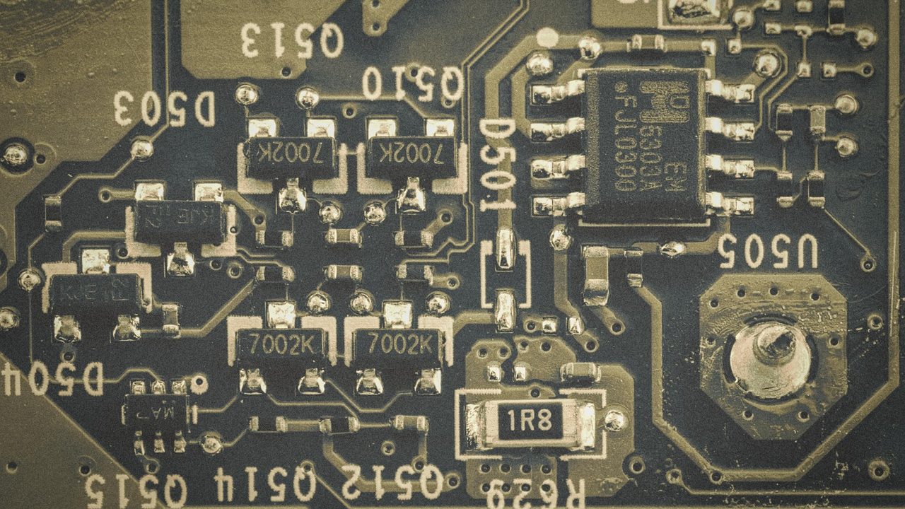 A glowing digital padlock icon overlaid on a circuit board macro photograph.