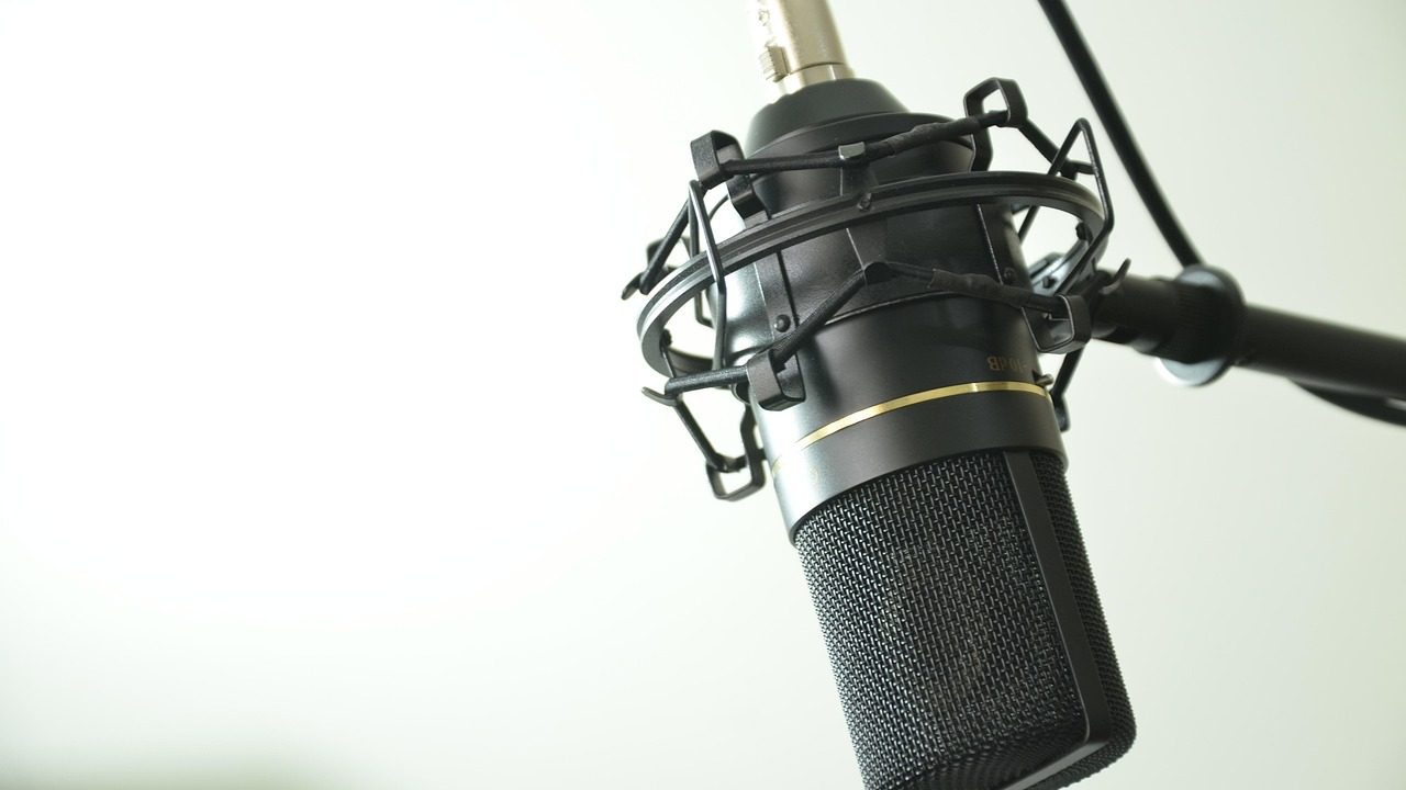 Two professional microphones on a broadcast desk in a radio studio.