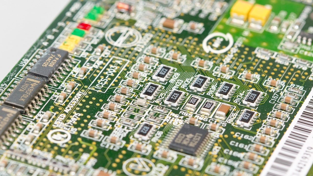 Close-up photograph of an aged integrated circuit chip with visible gold wire bonds.