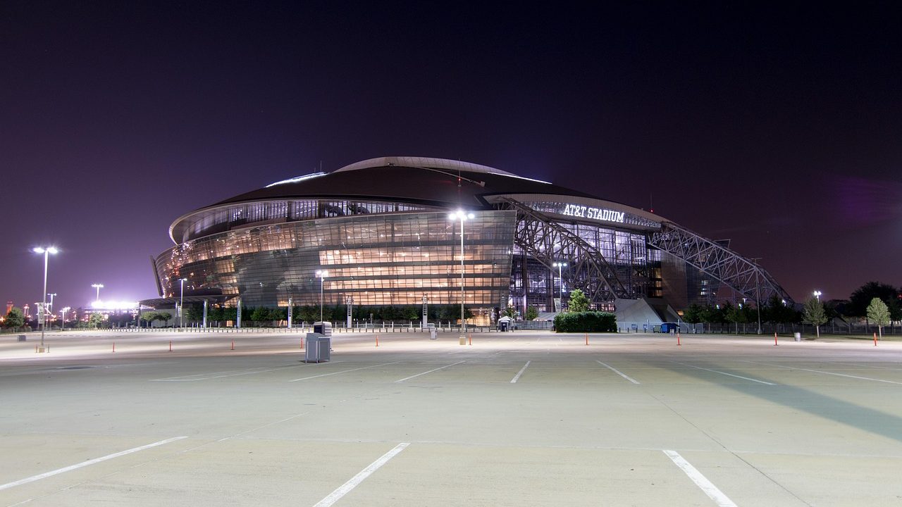 A large football stadium exterior under a clear sky.