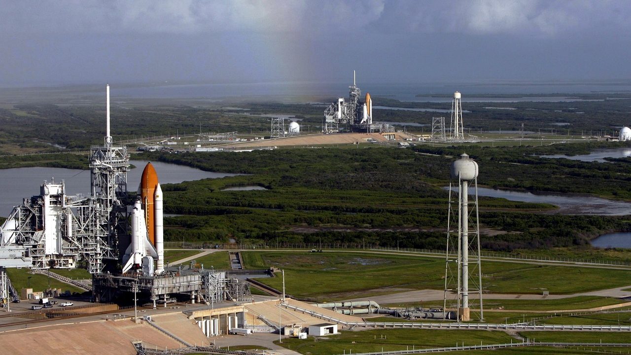 A rocket sits on a launch pad against a clear sky.