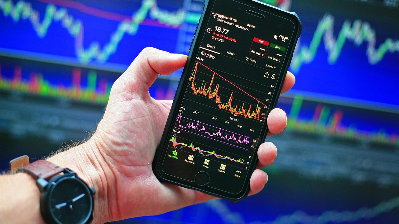 Financial trading screens display fluctuating oil price charts and market data.