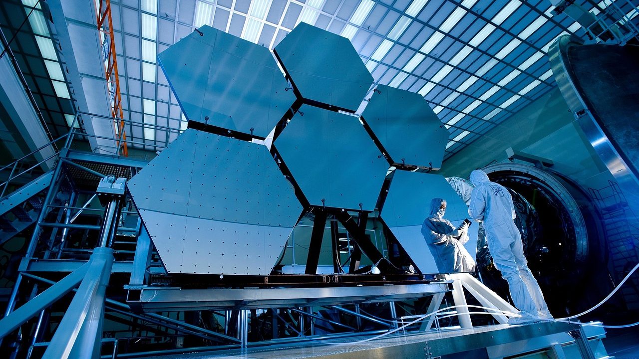 The gold-segmented primary mirror of the James Webb Space Telescope gleams in assembly.