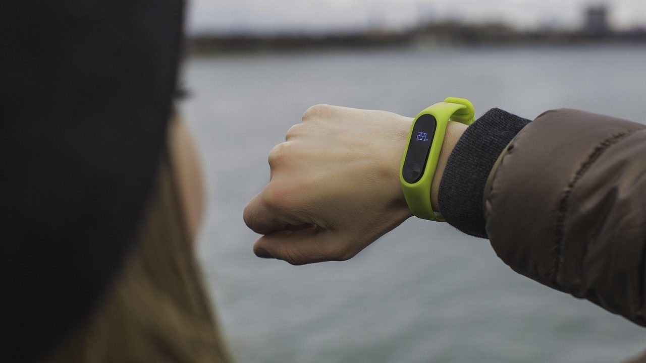 A fitness tracking wristband resting on a surface.