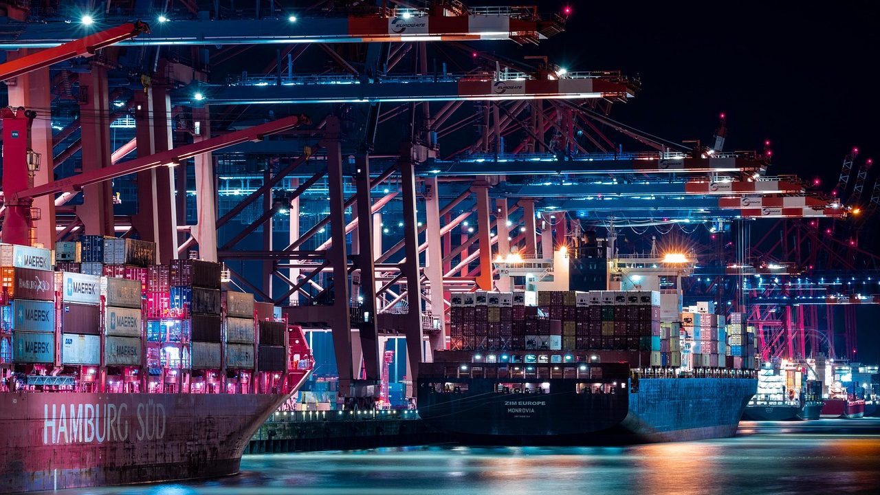 Large cargo container ships docked at a busy international shipping port.