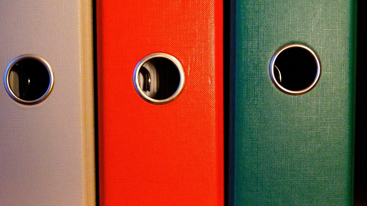 A folder of declassified intelligence documents spread on a table.