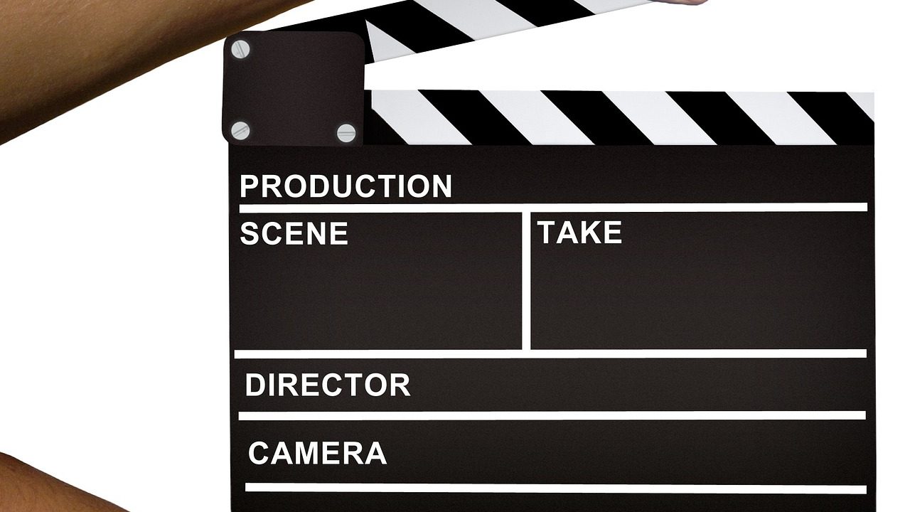 An empty film studio production lot with soundstage buildings and equipment trailers.