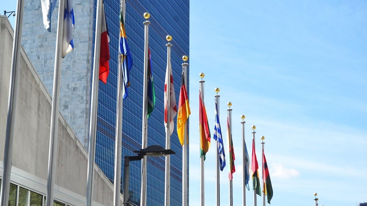 The curved rows of the UN Security Council chamber with national placards on the conference table.