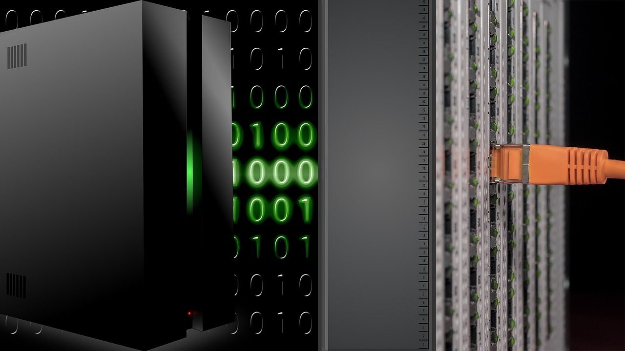 Rows of illuminated server racks in a darkened data center facility.