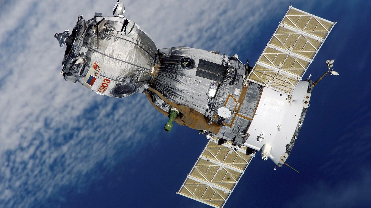 Illustration of dozens of small satellites arranged in orbital paths above a blue curved Earth.