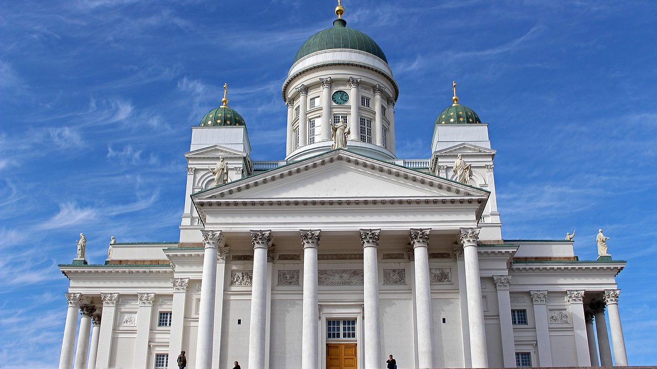 Stone steps leading to a government building entrance with a small gathering of people.
