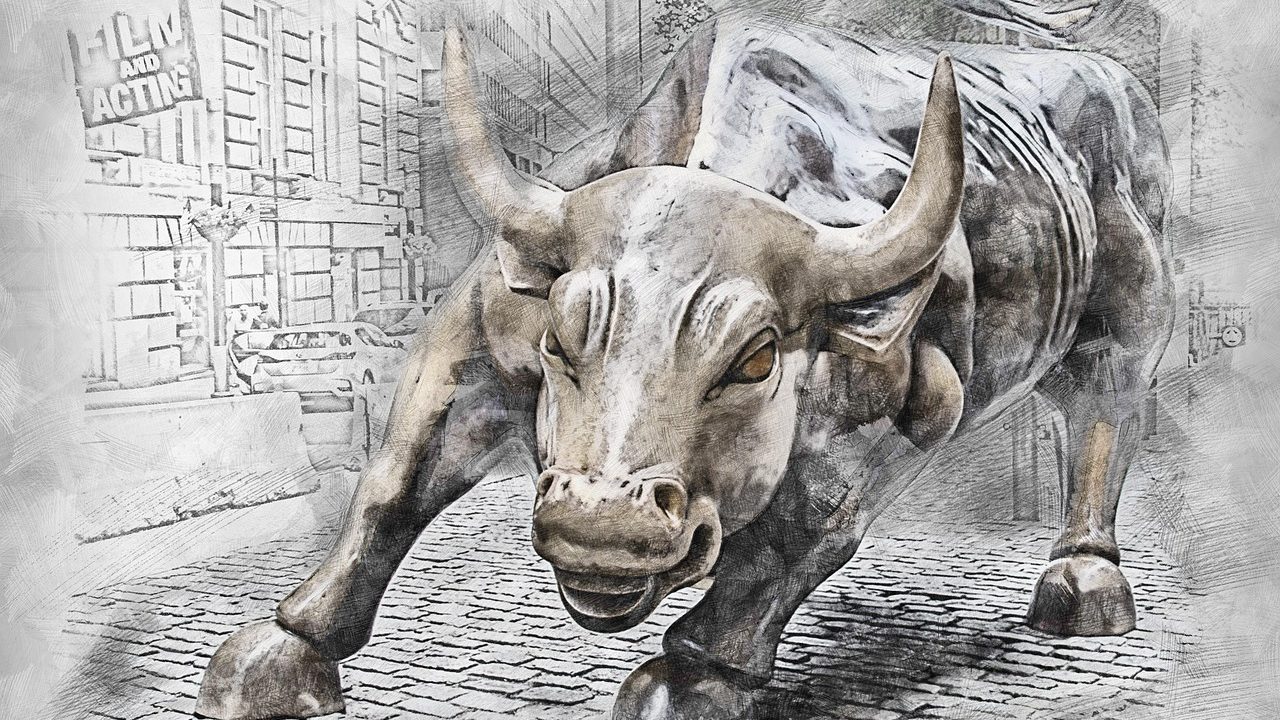 The iconic bronze bull statue on a city street in a financial district.