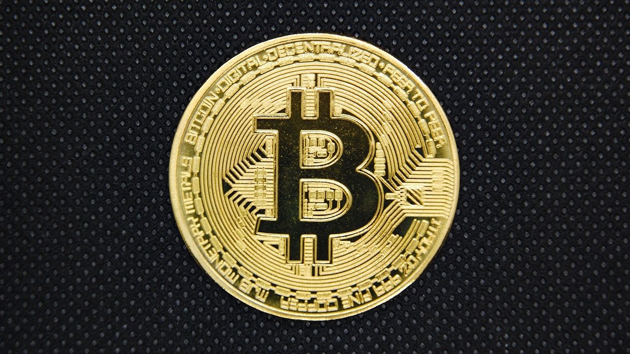 Close-up of a cryptocurrency hardware wallet device resting on a wooden surface.