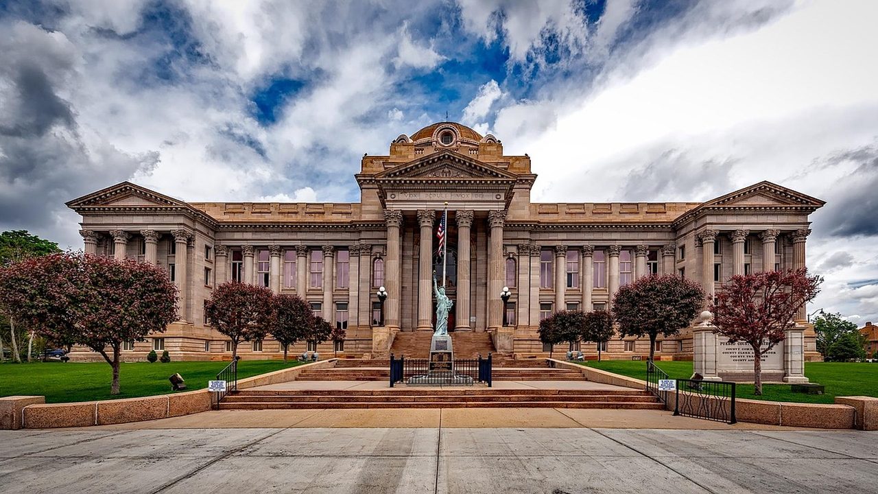 Stone columns and wide steps of a federal courthouse on a clear day.