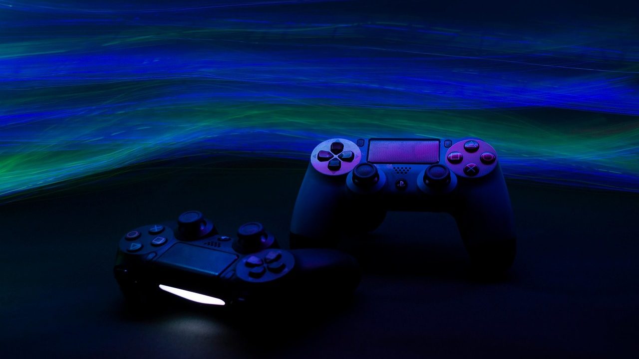 A modern video game controller resting on a dark surface under soft studio lighting.