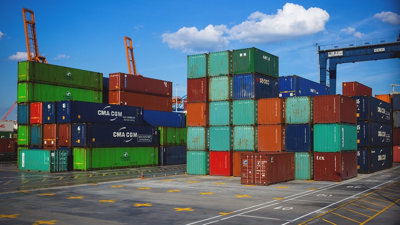 Rows of colorful shipping containers stacked at a commercial seaport.