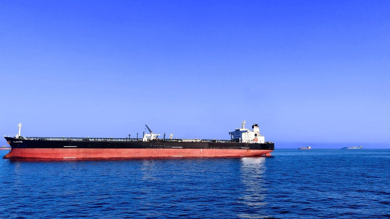 A large oil tanker sailing through open ocean waters under an overcast sky.
