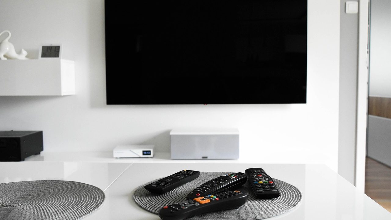 A large smart television glowing in a darkened living room.