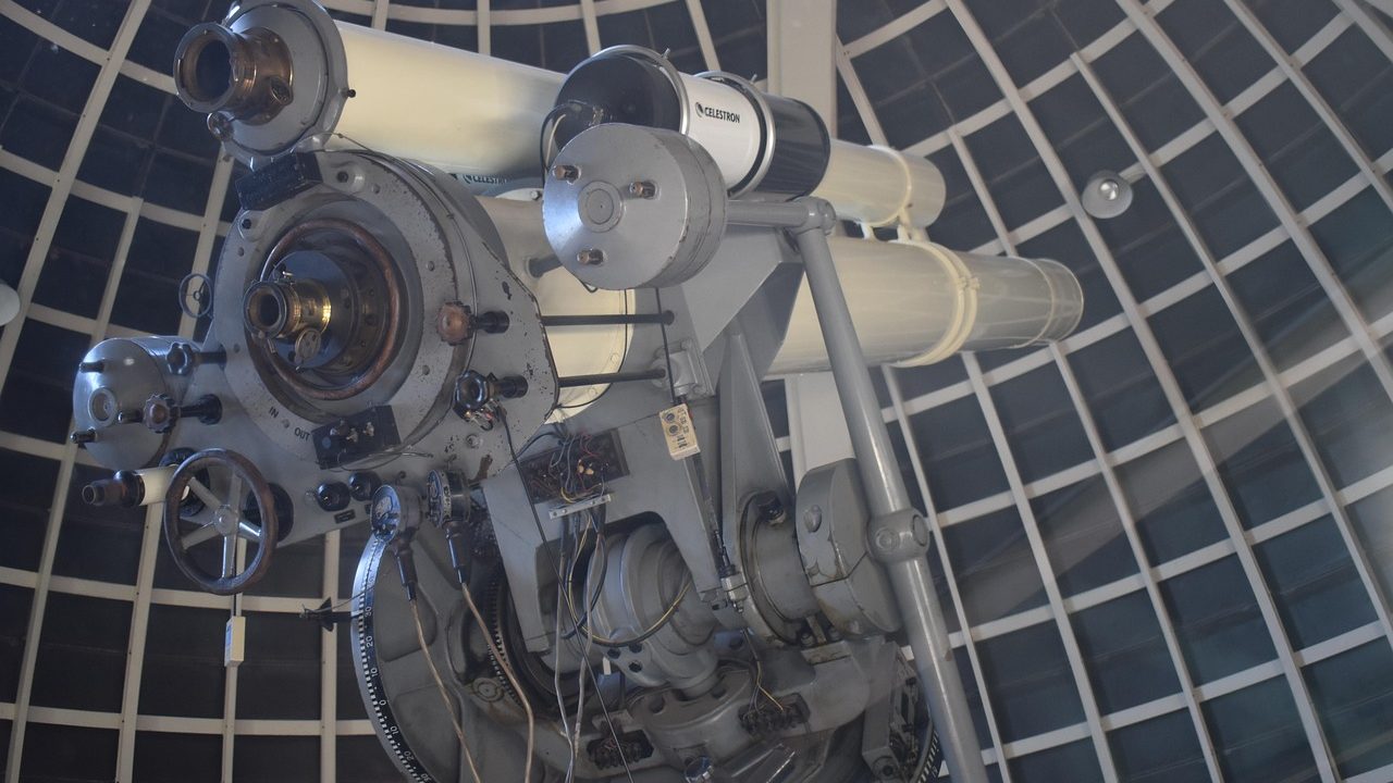 A large telescope dome silhouetted against a star-filled night sky.