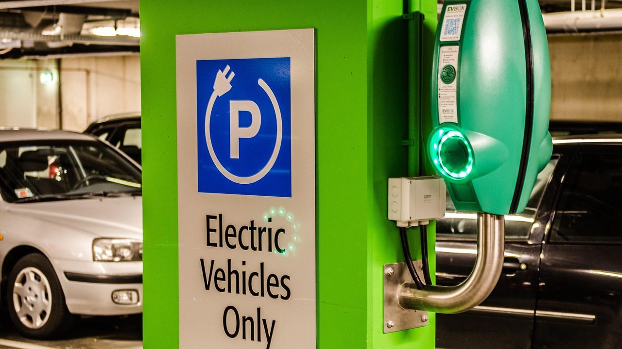 A row of electric vehicle charging stations in a parking lot on a clear day.