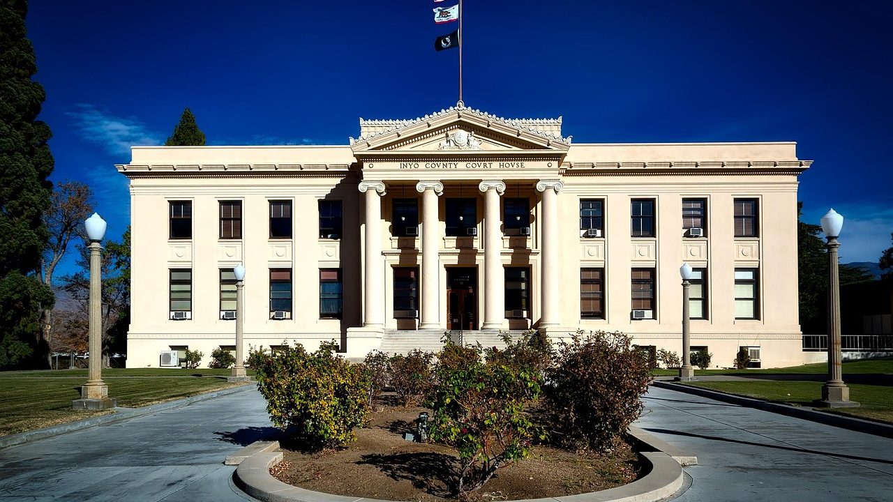 The white stone columns and broad steps of a classical courthouse facade.