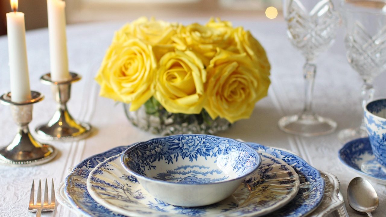 An elegantly set formal state dinner table with candelabras and floral centerpieces.