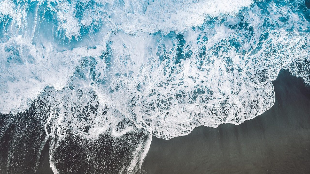 Ocean waves washing over a sandy Southern California beach during high tide.