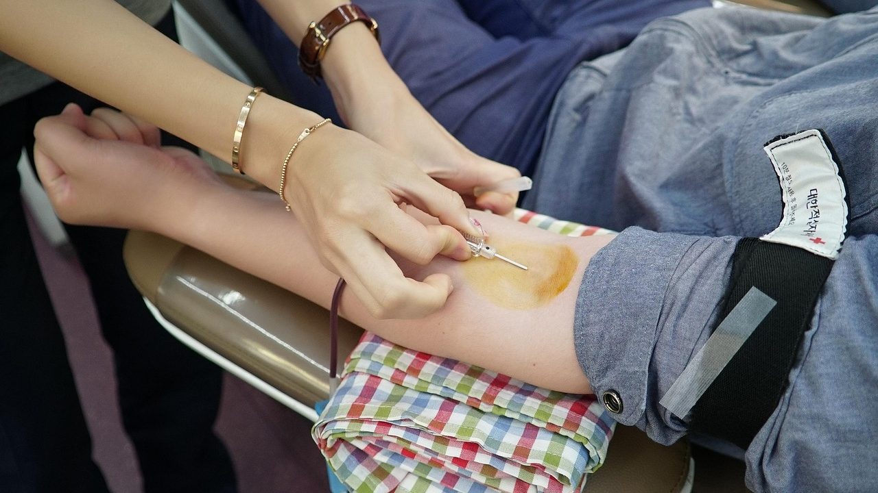 A blood donation station with chairs, equipment, and medical staff in a community health setting.