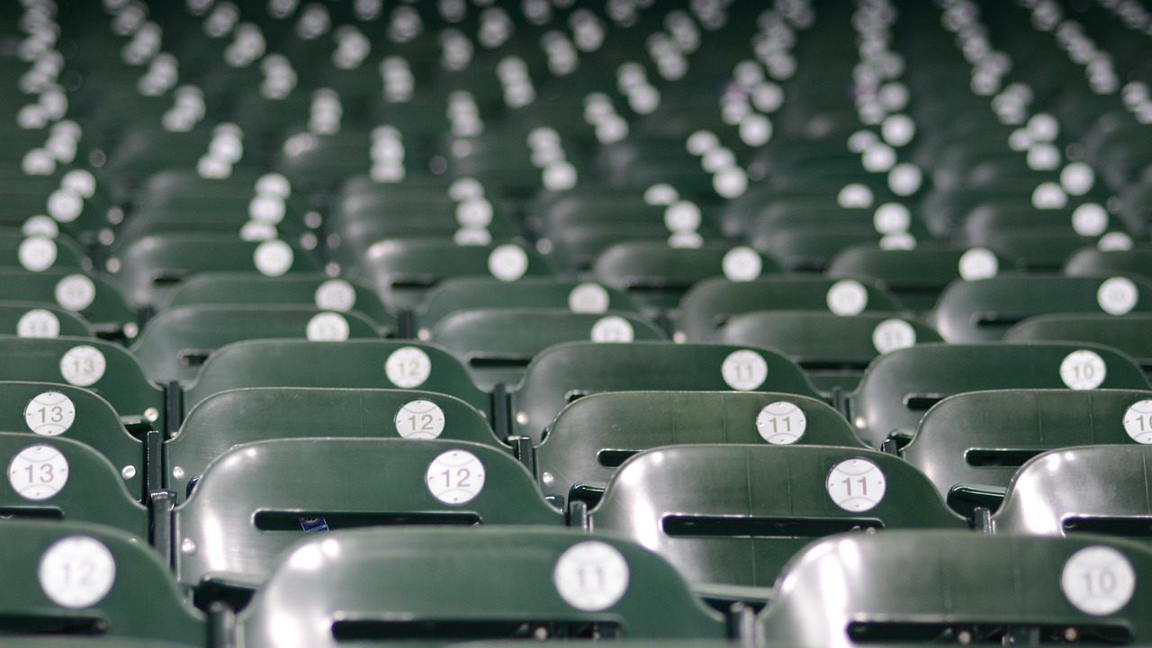 Rows of empty blue seats inside a modern baseball stadium before a game.